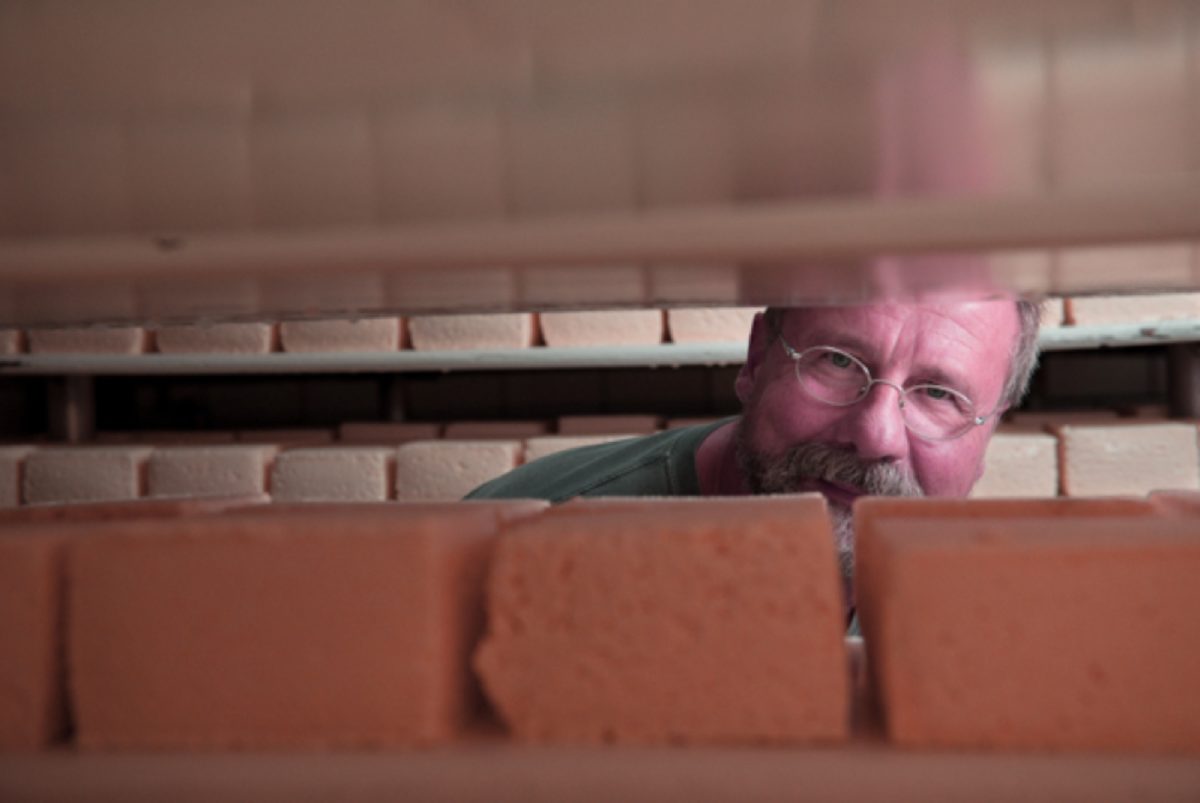 joe-widmer-smiling-behind-blocks-of-brick-cheese